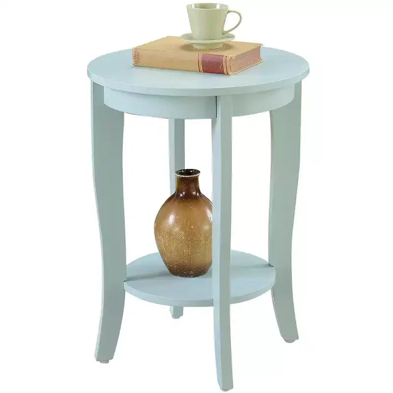 Table d'appoint ronde Belmont avec étagère inférieure, pieds incurvés et finition lisse, idéale pour les coins de salon ou de chambre.